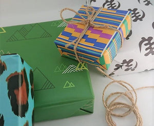 Christmas and birthday gifts in bright wrapping papers from The Copper Fruit.  With rope